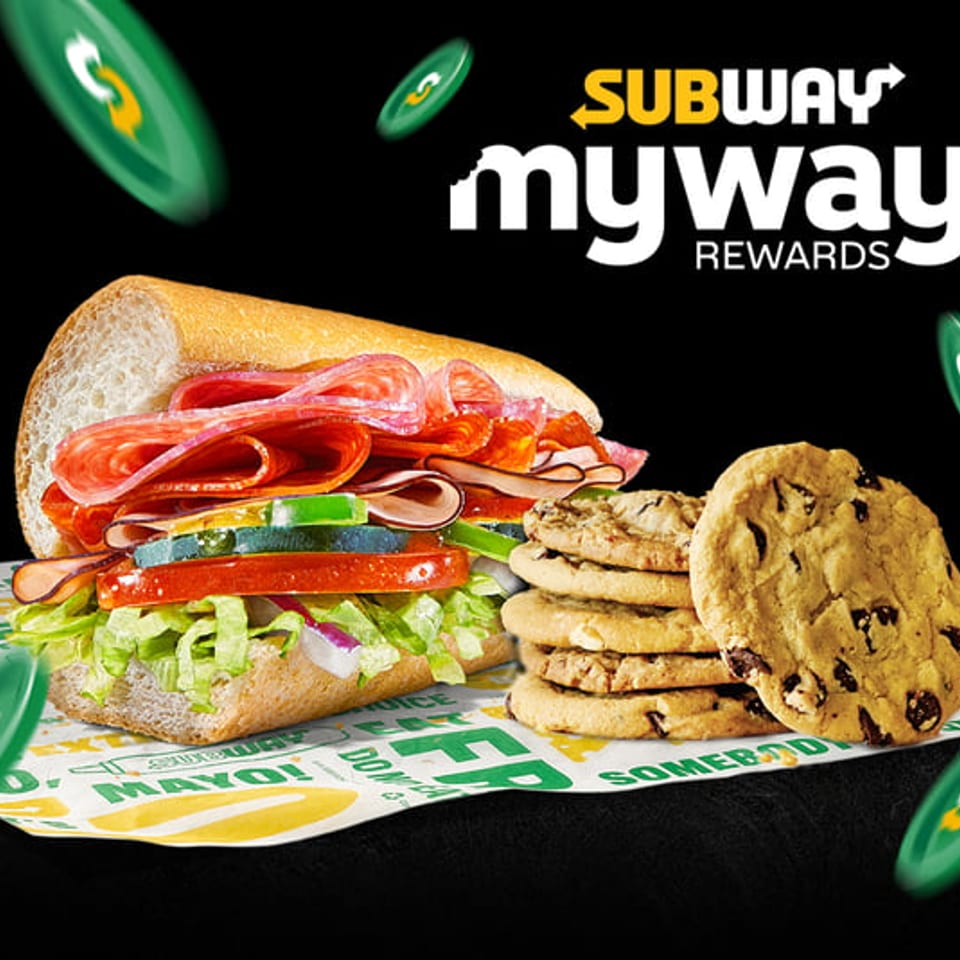 Subway sandwich with cookies on branded paper, with "Subway MyWay Rewards" text and green tokens.